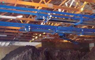 Patz conveyors mounted to the rafters of a storage room.