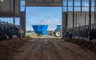 Side view of Patz 800 Series II 350 Trailer Single Screw Vertical Mixer at end of barn