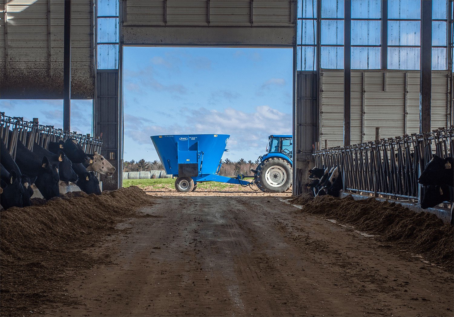 Side view of Patz 800 Series II 350 Trailer Single Screw Vertical Mixer at end of barn