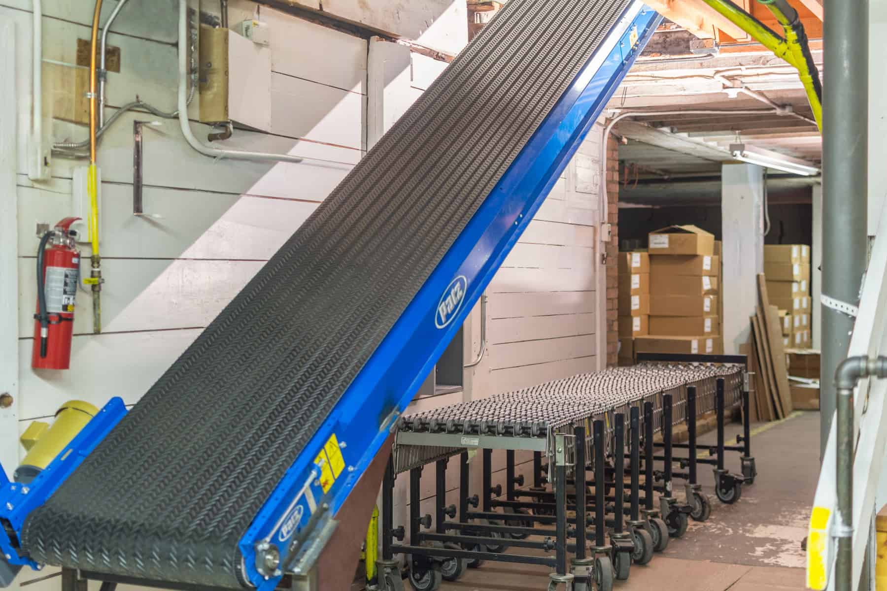 Patz conveyor in warehouse set at 45 degree angle with cleated belt.