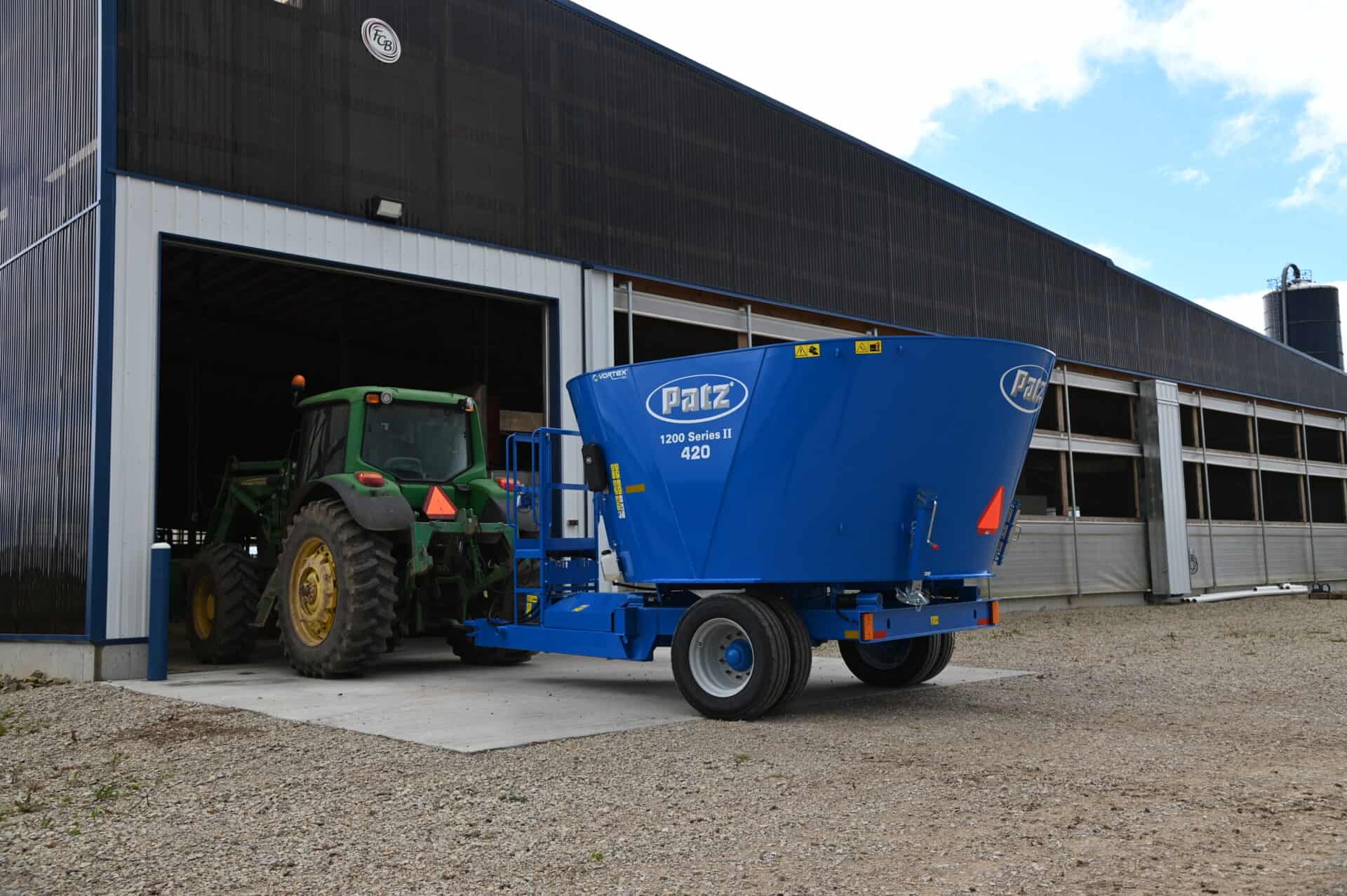 Patz 1200 Series II 420 Trailer Single Auger Vertical Mixer entering barn